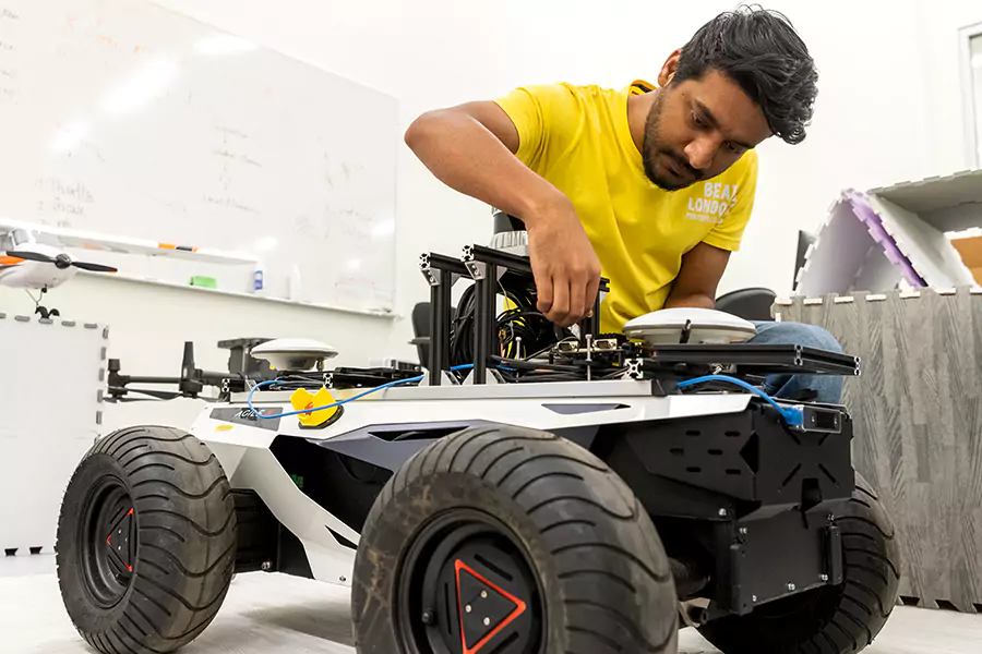 A person inspects an autonomous vehicle.
