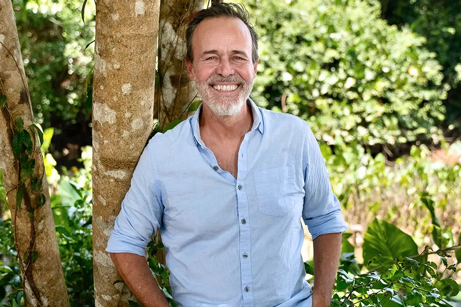 Professor Brondizo stands smiling in front of a tree.