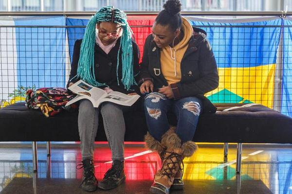 Two IU Indianapolis students sitting in front of international flags.